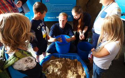 Am Nordsee-Tag suchen Kinder im Sand nach Gegenständen, die dort nicht hingehören