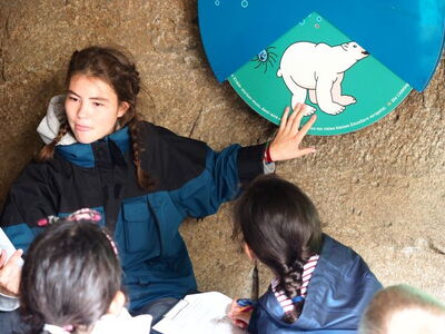 Eine Zooschulmitarbeiterin arbeitet mit Kinder im Rahmen einer Zooschulexpedition