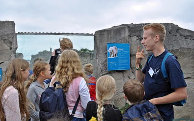 Niklas erklärt einer Gruppe Kindern, wie die Fortpflanzung bei Eisbären funktioniert