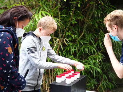 Zooschulmitarbeiter Niklas beim Forschertag der Weser-Elbe Sparkasse mit einem Kind