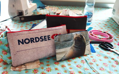 Aus alten Zoo-Bannern wurden mit Besuchenden kleine Taschen genäht